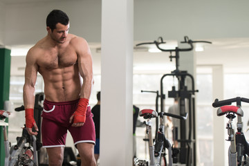 Fototapeta na wymiar Handsome Man With Red Boxing Gloves In Gym