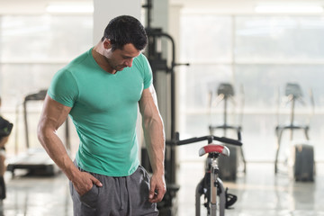 Naklejka na ściany i meble Strong Man in Green T-shirt Background Gym