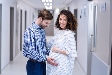 Fototapeta premium Man comforting pregnant woman in corridor