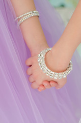 Hands with bridesmaids to wear bracelets of precious stones closeup