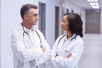 Doctors standing with arms crossed in corridor