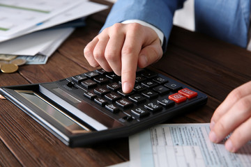 Man sitting at table with calculator