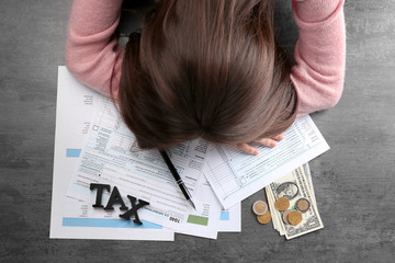Tired businesswoman of calculating expenses at desk in office