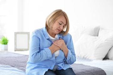Senior woman having heart attack at home