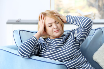 Senior woman suffering from headache at home
