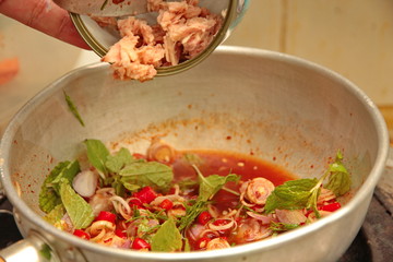 Spicy and sour mixed herb salad with tuna served .