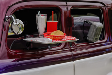 Drive in movie theater speaker and food tray on vehicle