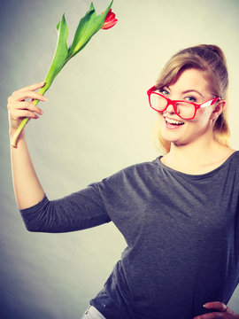 Nerdy girl waving flower.