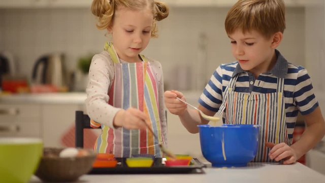 Two happy children playing and having fun during baking Easter sweets