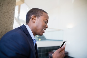 Fototapeta premium Worried businessman looking at mobile phone