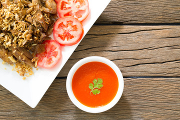 Fried chicken piece sprinkled on top with fried garlic eaten wit