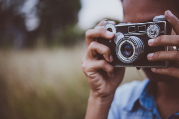 Young hipster woman took photo by vintage camera.