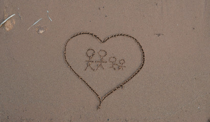 Heart drawn in sea beach sand, family concept