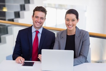 Happy business executives sitting at desk