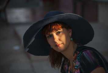 Beautiful young woman in a hat outdoors