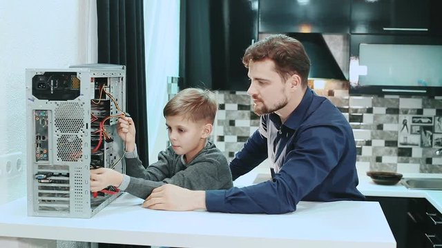 Father and son repair a computer.