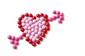 Red and Pink Coated Candy shaped in a heart isolated on white ba