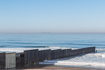 The international border wall extending out into the ocean and separating San Diego, California from Tijuana, Mexico at Border Field State Park, the most Southwesternly location in the United States.