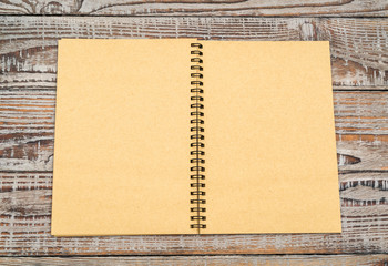 Blank notebook mock up on wood background .