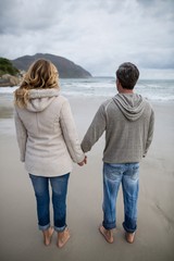 Couple standing with holding hands on the beach