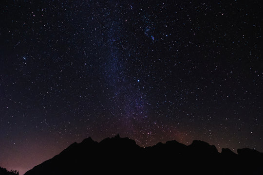 Silhouette mountain peak at night with sky full of stars and milky way