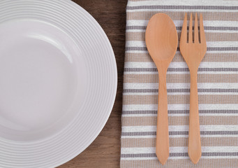 Wooden spoon and White plate  on the wooden