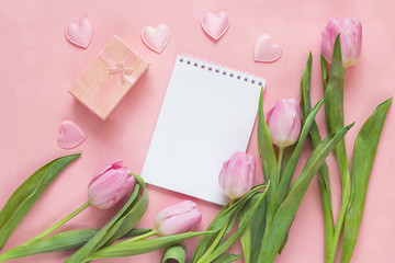 Blank open notepad with tulips and hearts on a pink background.