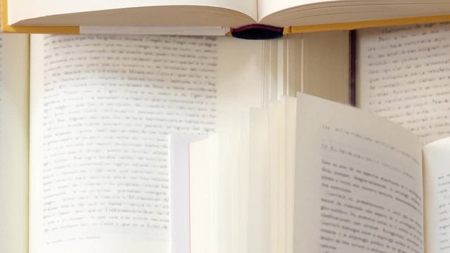 Many open books piled up. unreadable text
