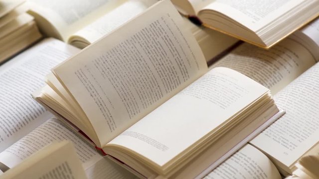 Many open books piled up. unreadable text
