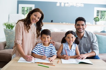 Parents assisting their kids in doing homework at home