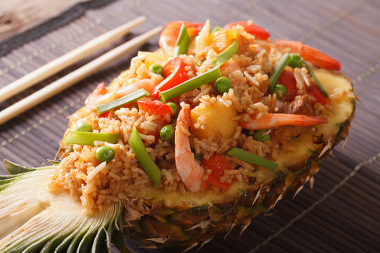 Pineapple stuffed with fried rice, shrimp and vegetables close-up. Horizontal