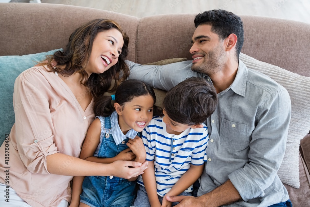 Poster Parents and kids having fun in living room