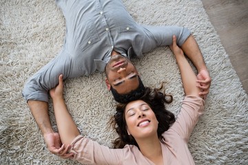 Couple relaxing on rug in living room