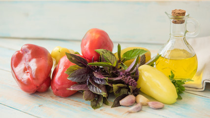 Pepper red, yellow, oil bottle, and Basil on a wooden table