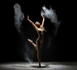 Obraz na płótnie Canvas Long haired blonde dancing in white dust cloud