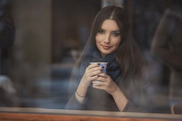 Portrait of a beautiful young woman enjoys a cup of coffee at morning 