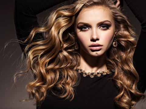 Beautiful woman with long curly hair and gold jewelry