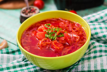 Traditional Ukrainian Russian vegetable borscht soup on green bowl.