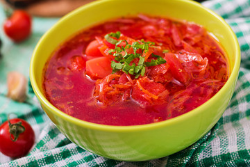 Traditional Ukrainian Russian vegetable borscht soup on green bowl.
