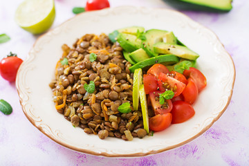 Diet menu. Healthy lifestyle. Lentils porridge and fresh vegetables - tomatoes and avocado on plate.