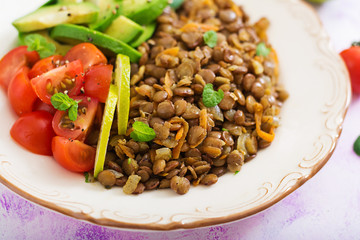 Diet menu. Healthy lifestyle. Lentils porridge and fresh vegetables - tomatoes and avocado on plate.