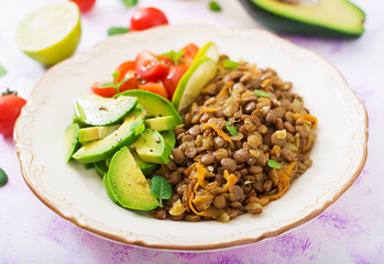 Diet menu. Healthy lifestyle. Lentils porridge and fresh vegetables - tomatoes and avocado on plate.