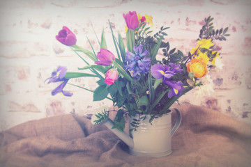 Spring flower arrangement against a rustic background