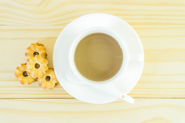 Coffee cup and candy on wood table background.