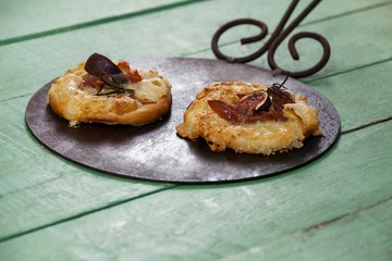 Delicious pizza served on pizza tray on wooden plank