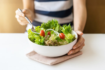 Young woman eating fresh organic vegetarian salad