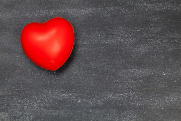 Obraz premium Red heart on a dark wooden table.