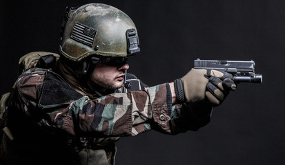 United states Marine Corps special operations command Marsoc raider with pistol. Studio shot of Marine Special Operator black background