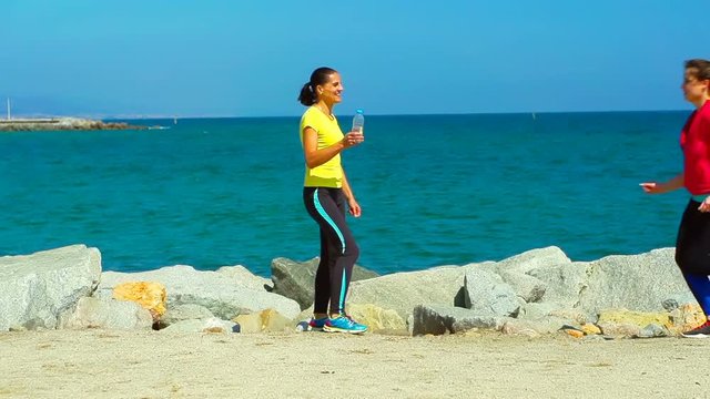 Couple running next to the navy blye sea, steadycam shot, slow motion shot at 240fps
