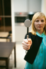 blonde woman in the kitchen, holding a cutlery